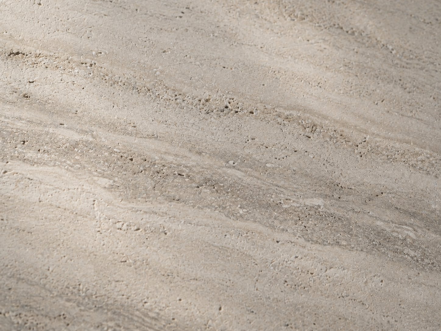 Nahaufnahme einer Travertinplatte mit sichtbarer Maserung im Streiflicht